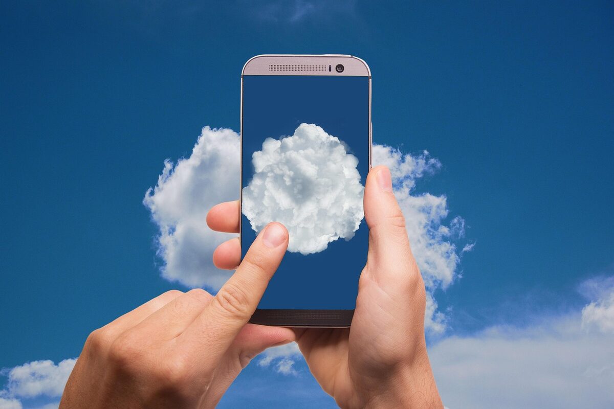 Hands holding a phone with a cloud above it