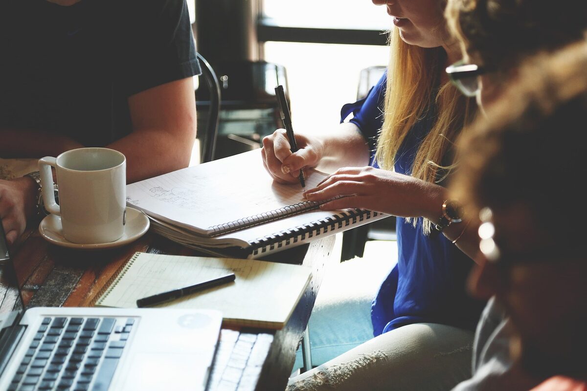 Colleagues reviewing notes together at a meeting table